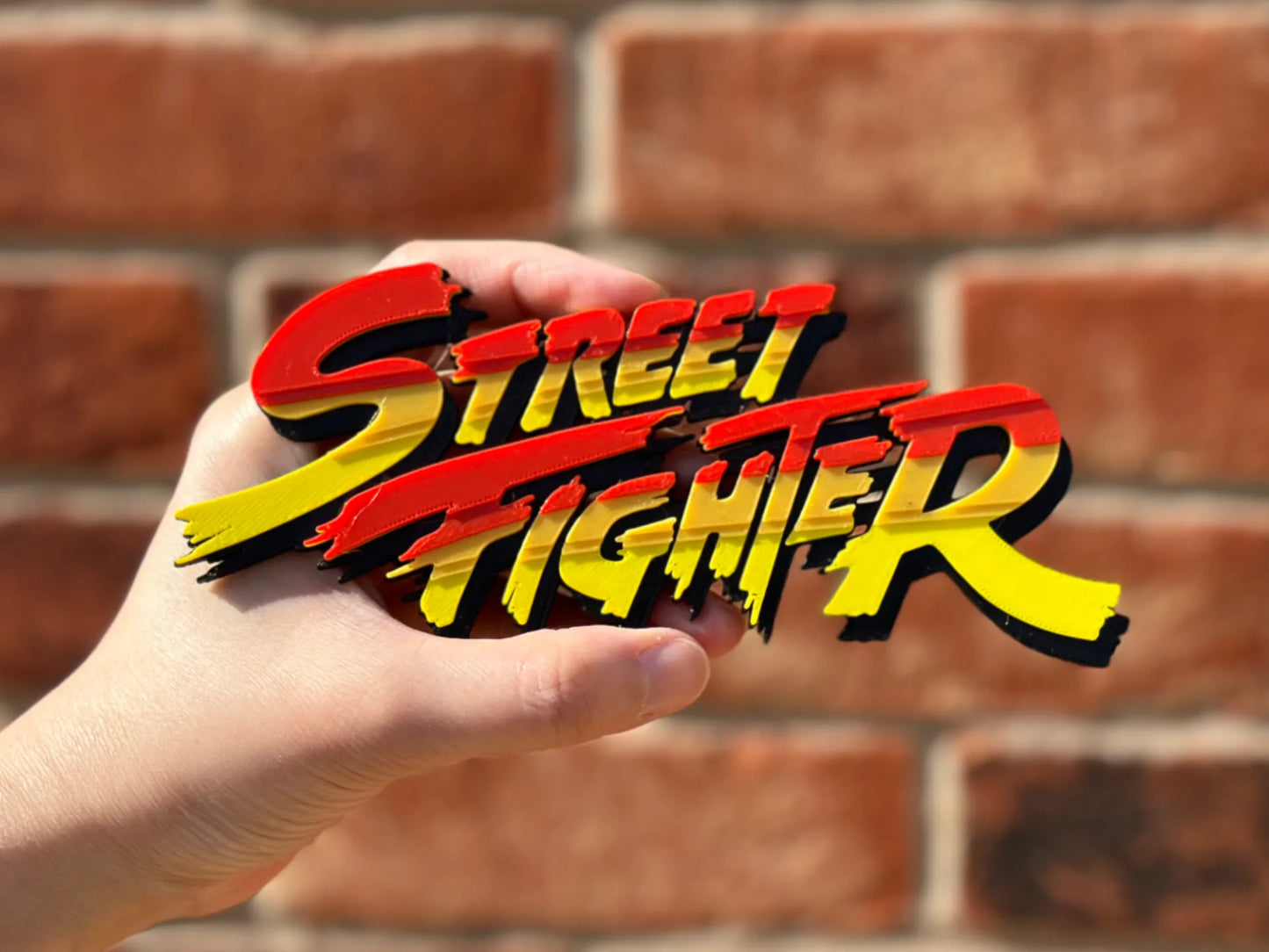 Logo 3D de Street Fighter con acabado mate y gran nivel de detalle para decoración de vitrinas, escritorios y zonas gaming.