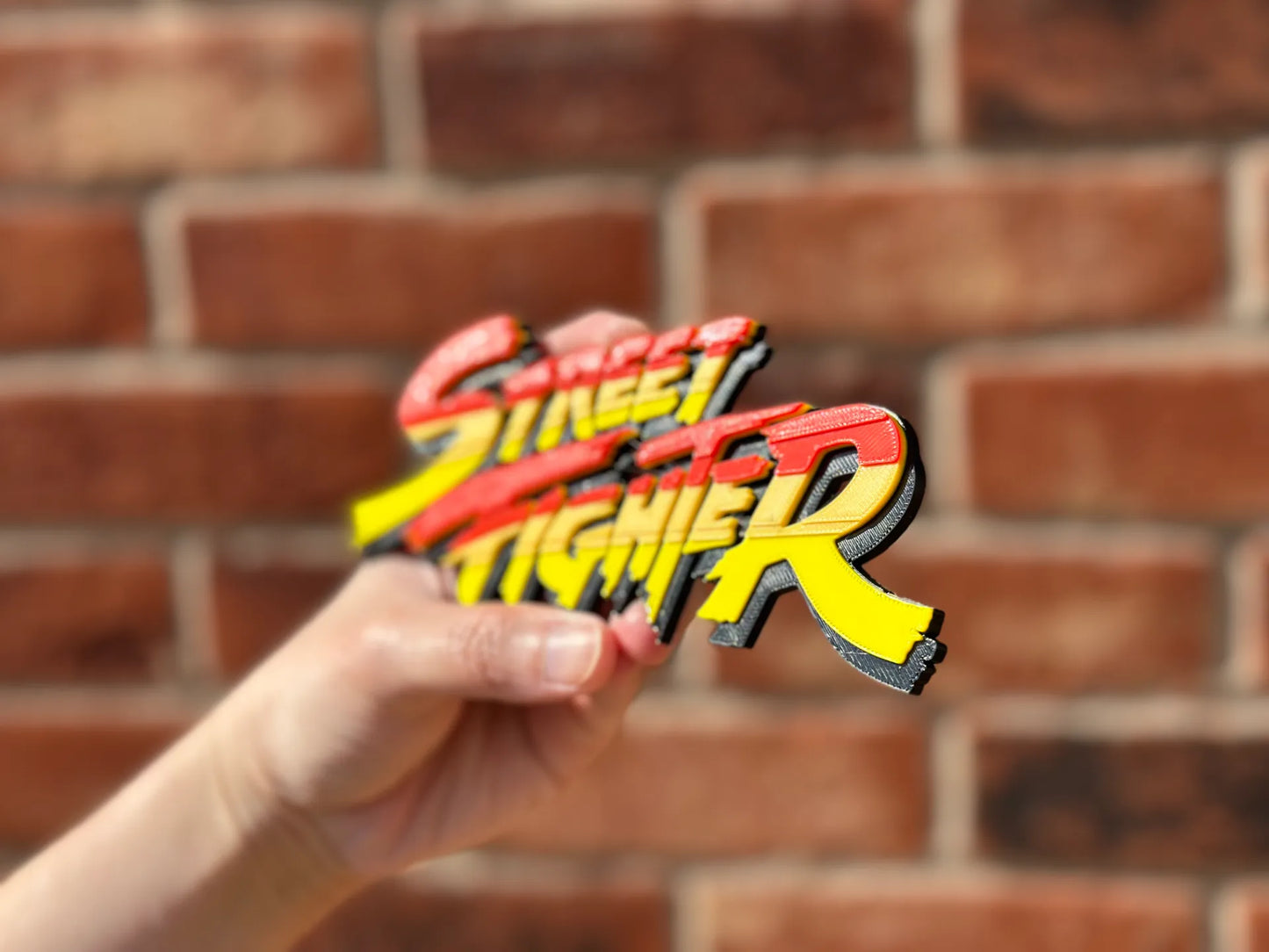 Logo 3D de Street Fighter con acabado mate y gran nivel de detalle para decoración de vitrinas, escritorios y zonas gaming.