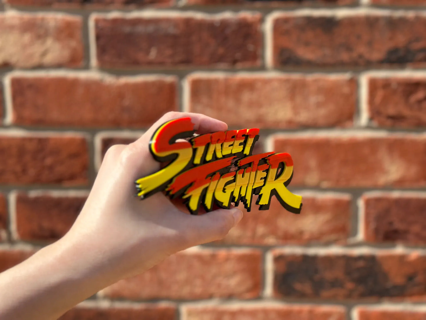 Logo 3D de Street Fighter con acabado mate y gran nivel de detalle para decoración de vitrinas, escritorios y zonas gaming.