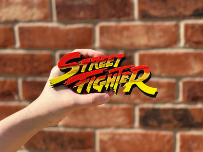 Logo 3D de Street Fighter con acabado mate y gran nivel de detalle para decoración de vitrinas, escritorios y zonas gaming.