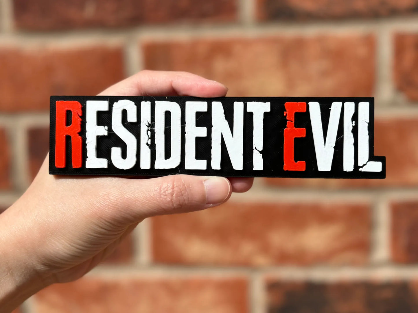 Logo 3D de Resident Evil con acabado mate y gran nivel de detalle para decoración de vitrinas, escritorios y zonas gaming.